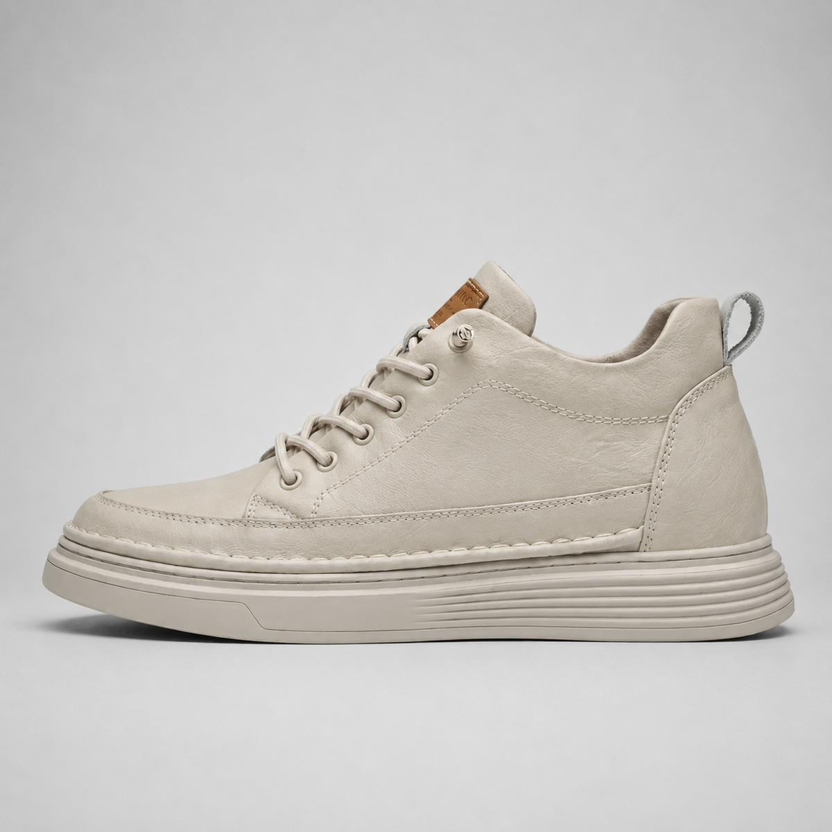A single low-top lace-up sneaker in a light cream or off-white suede-like material, shown in a side profile against a neutral light gray background.